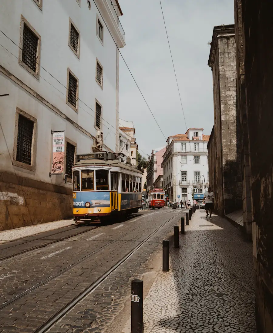 Tramway jaune remontant une rue pavée de Lisbonne